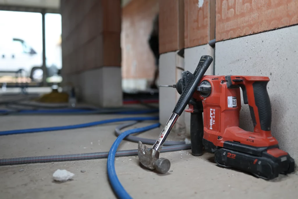 Boorhamer en wachtbuizen op de vloer van een nieuwbouw