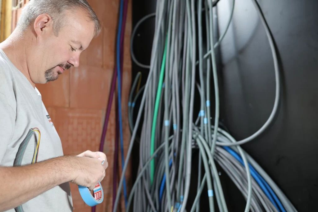 Elektricien bundelt en markeert de bekabeling in een nieuwbouwwoning