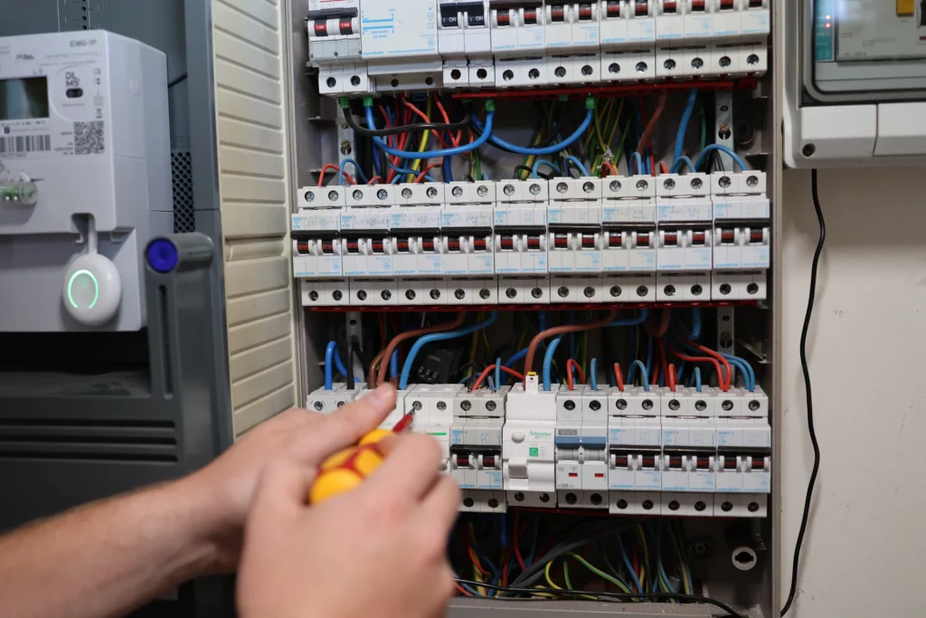 Elektricien sluit automaten aan in een open zekeringkast